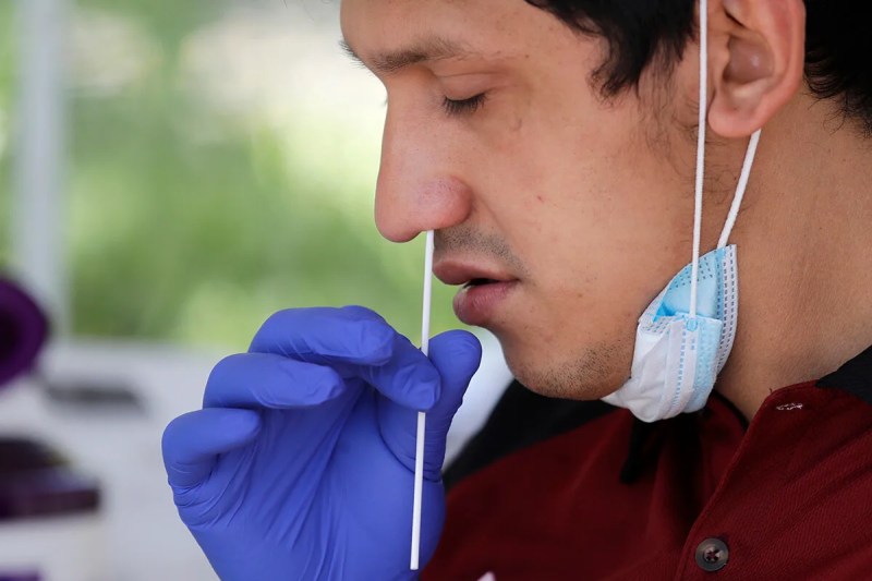 man self-administering coronavirus nasal swab test