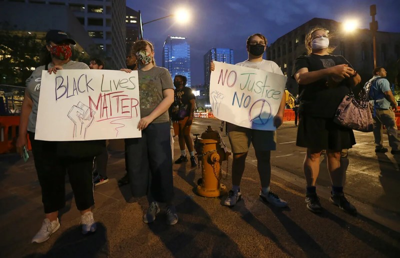 protesters holding signs supportive of Black Lives Matter