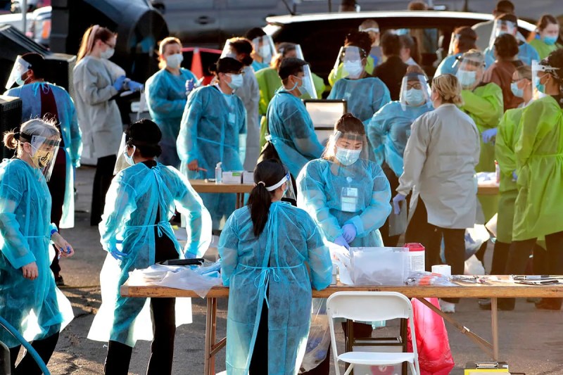 crowd of medical professionals wearing PPE working outside