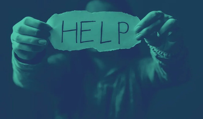 woman holding sign that says "help"