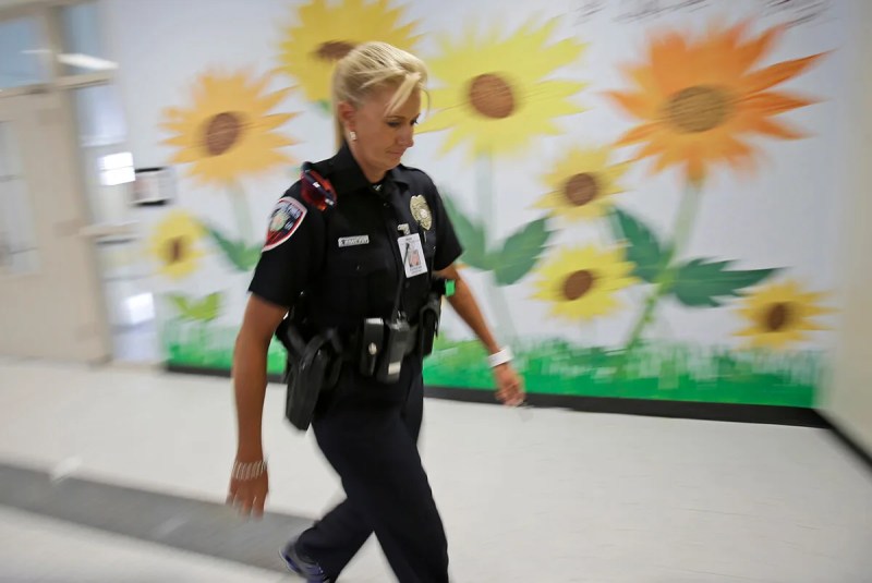 school resource officer walking down school hallway