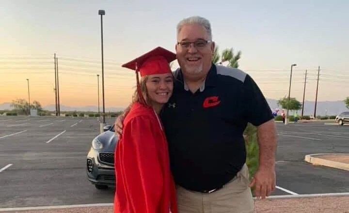 Dr. Nelson standing with student in graduation regalia