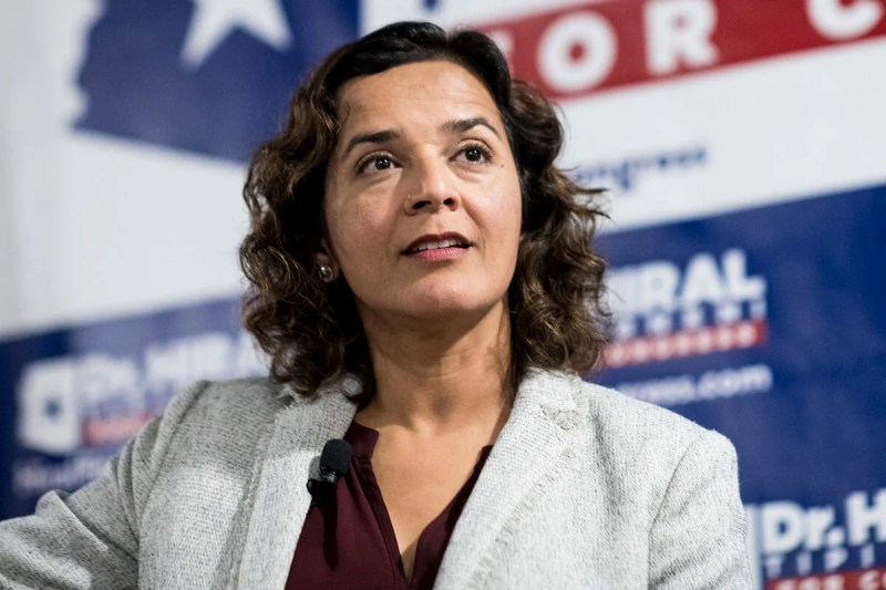 headshot of Dr. Hiral Tipirneni in front of campaign signs