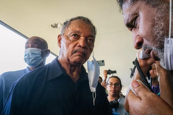 Rev. Jesse Jackson (C), listens during a sit-in demonstration outside the office of Sen. Kyrsten Sinema (D-AZ) on July 26, 2021 in Phoenix, Arizona.