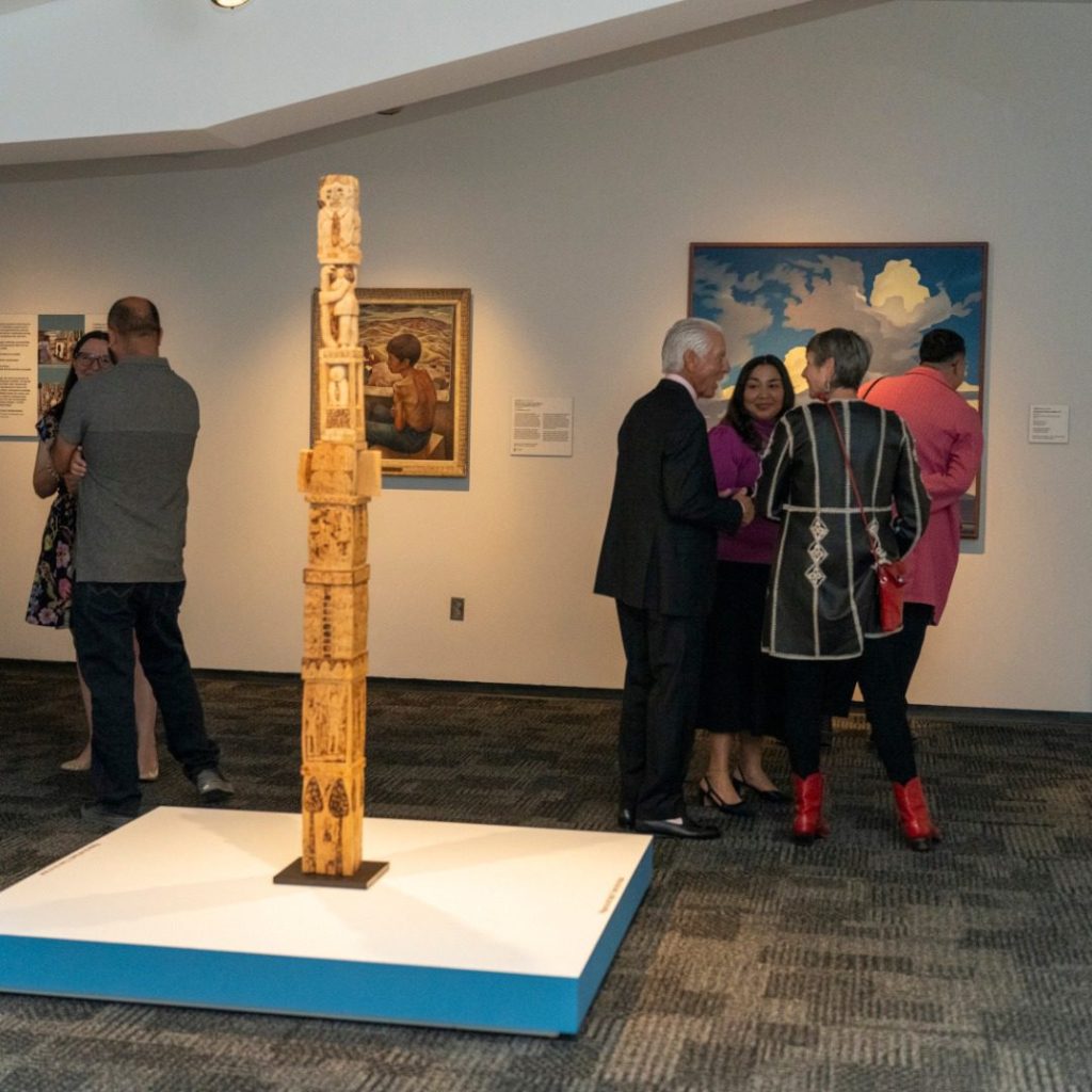 People mingling at Phoenix Art Museum in front of a painting.