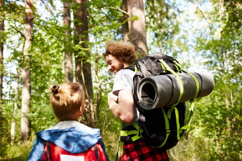 Man and child hiking in the woods.