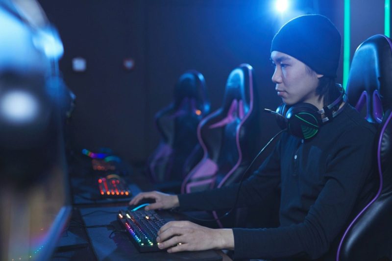 Young man wearing a beanie playing a video game.