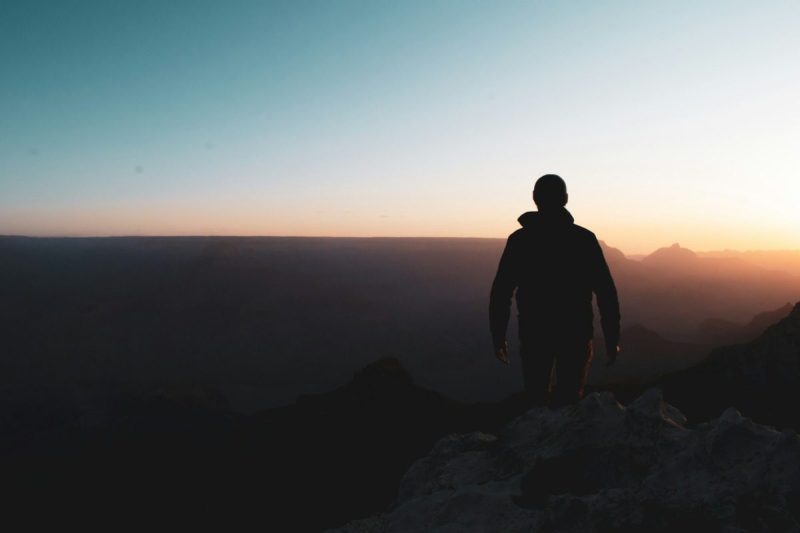Silhouette of a man walking at dusk.