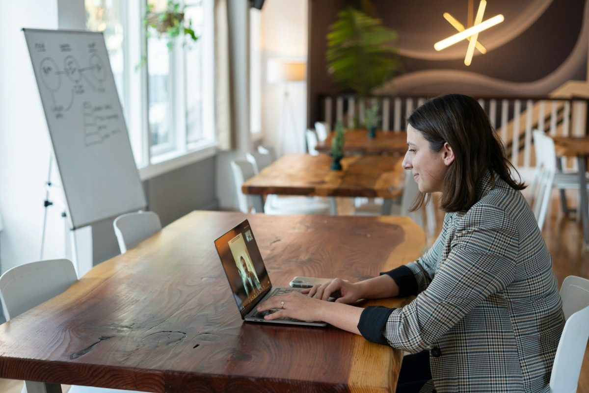 Young brunette woman typing on a laptop.