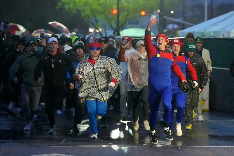 Fans run onto the course prior to the continuation of second round of the Phoenix Open golf tournament