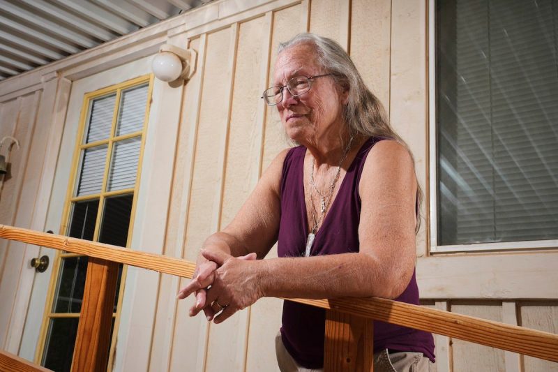 older woman standing on porch