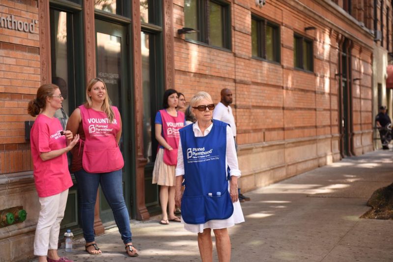 photo of planned parenthood clinic with volunteers standing outside.