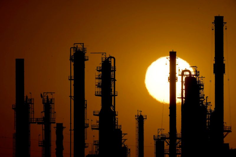 The CHS oil refinery is silhouetted against the setting sun