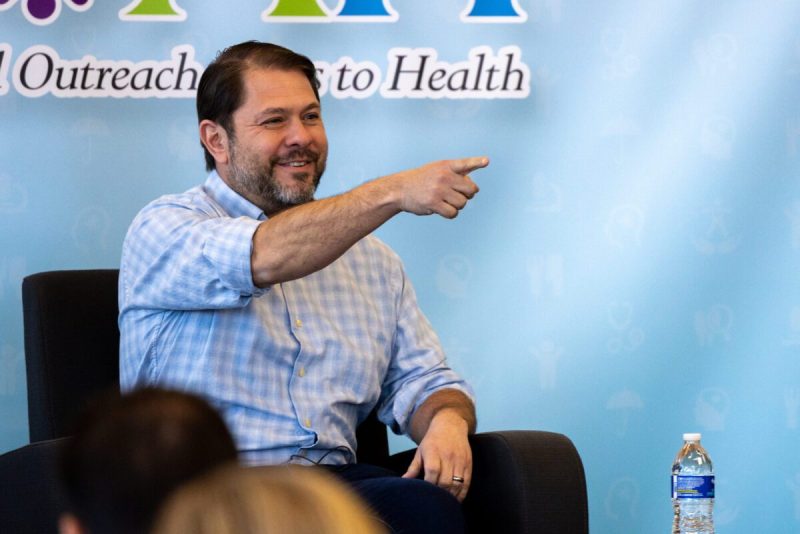 Ruben Gallego sitting on stage and pointing