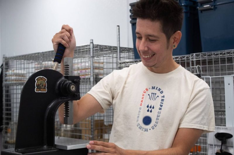 a man smiles behind a machine