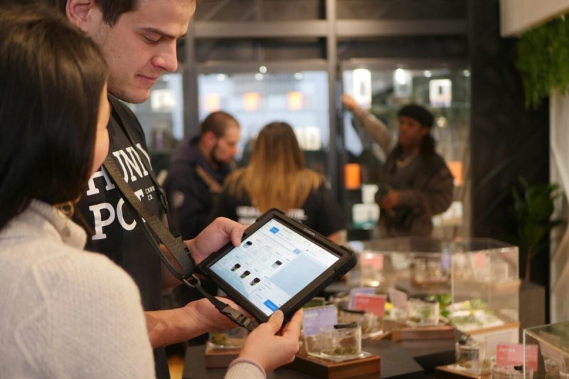 people look at a digital screen in an arizona dispensary
