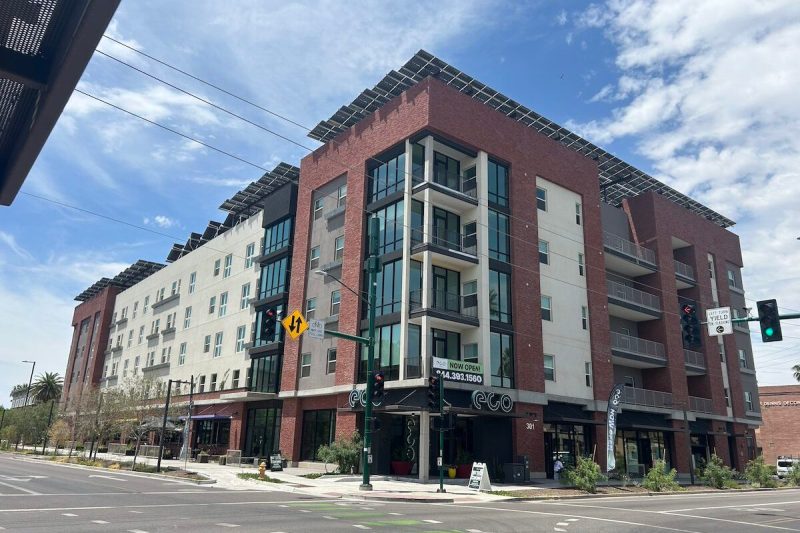 corner view of apartment building with solar panels visible on roof