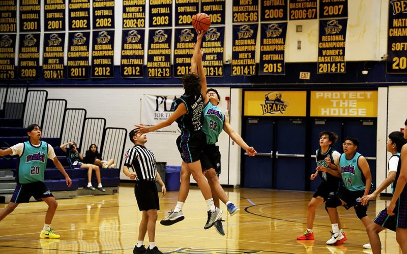 boys doing a jump ball in a basketball game