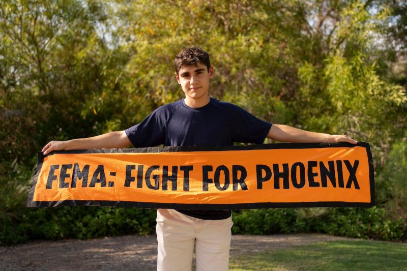 boy holding sign that says FEMA fight for phoenix
