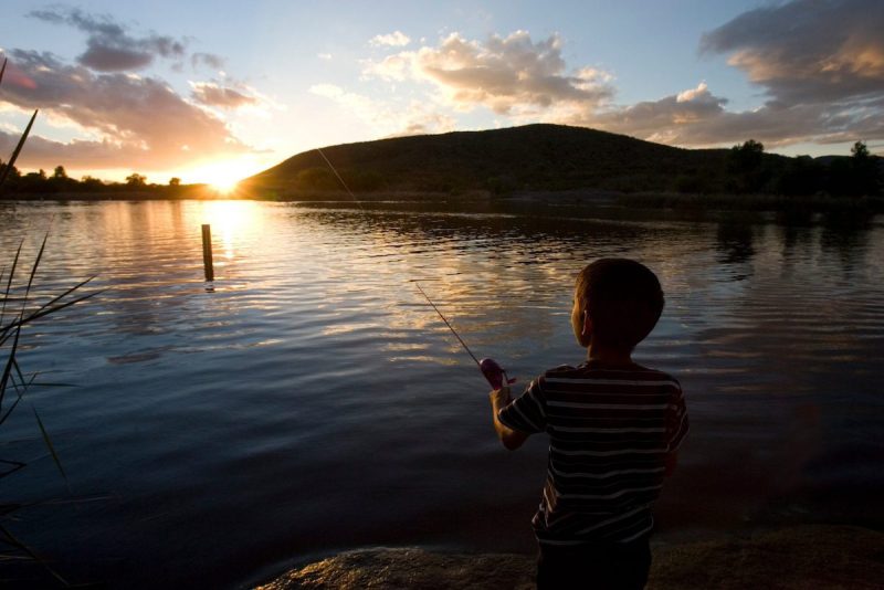 child fishing on a lake
