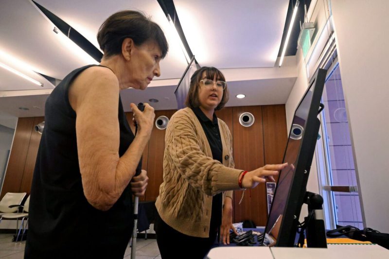 woman demonstrating something on a screen while another woman watches