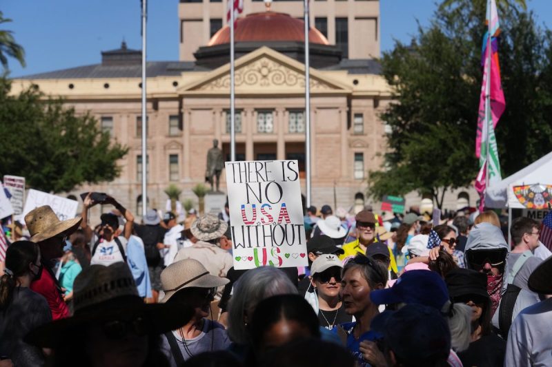 People protest Trump administration policies in front of the Arizona Capitol