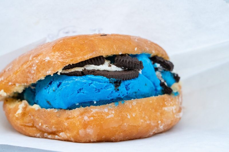 blue cookies and cream ice cream inside of a glazed donut