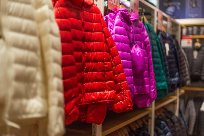 various colors of puffer coats hanging up