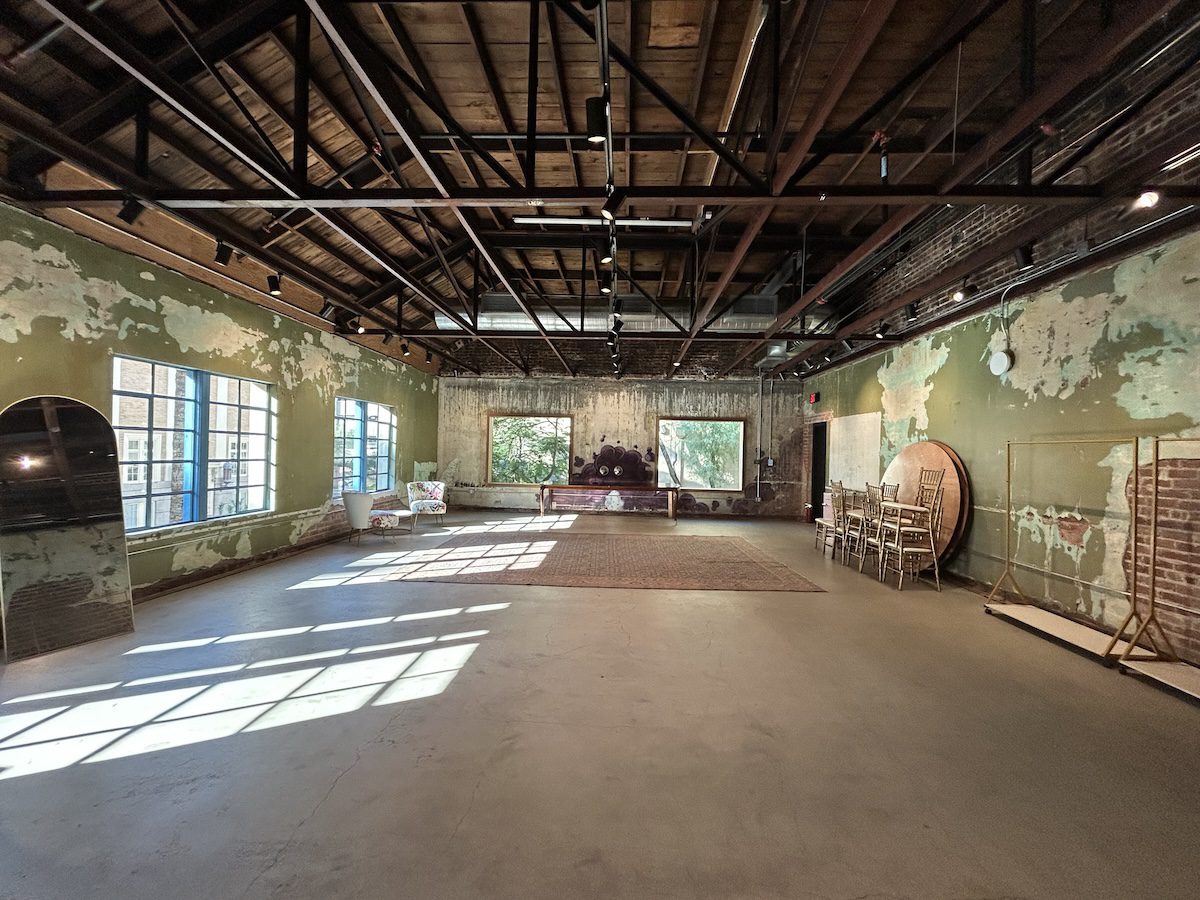 the inside of a large room with green peeling walls and a dark wood ceiling