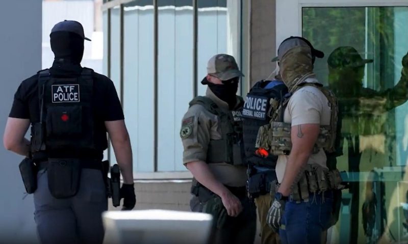 Masked ICE agents waiting for people as they leave immigration hearings in Phoenix