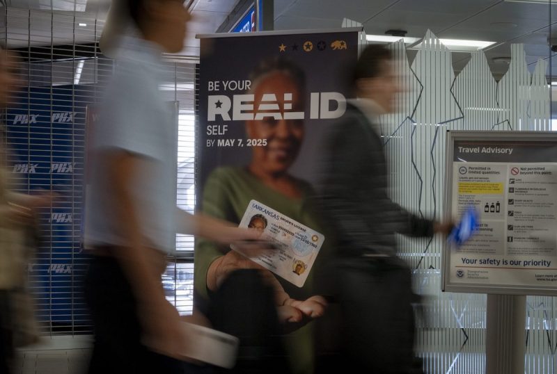 people walk past a Real ID sign in an airport