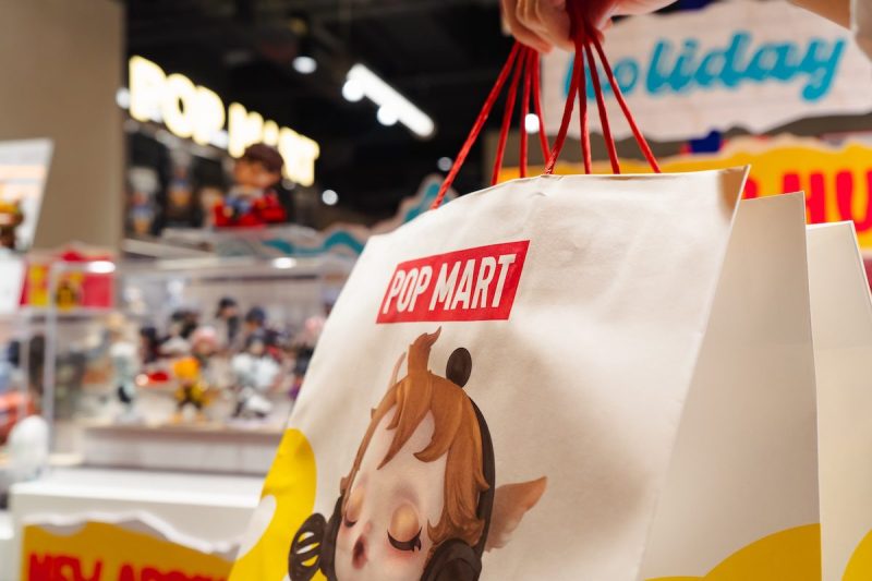 a closeup on a Pop Mart bag with a blurry background of a store